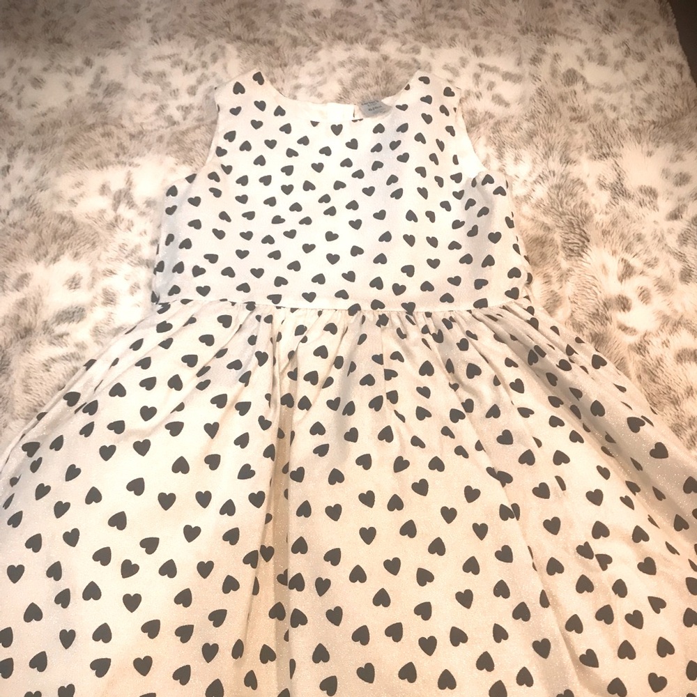 Dress is an iridescent white with black heart accents size 6-6x .